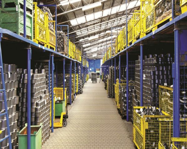A spacious warehouse aisle lined with metal containers stored on blue and yellow shelves, showcasing industrial storage solutions.